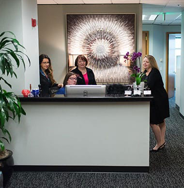 Photos Of The Firm's Office Interior, Attorneys, Attorneys And Staff In The Reception Area, And Canfield Madow Chap Sticks On Desk